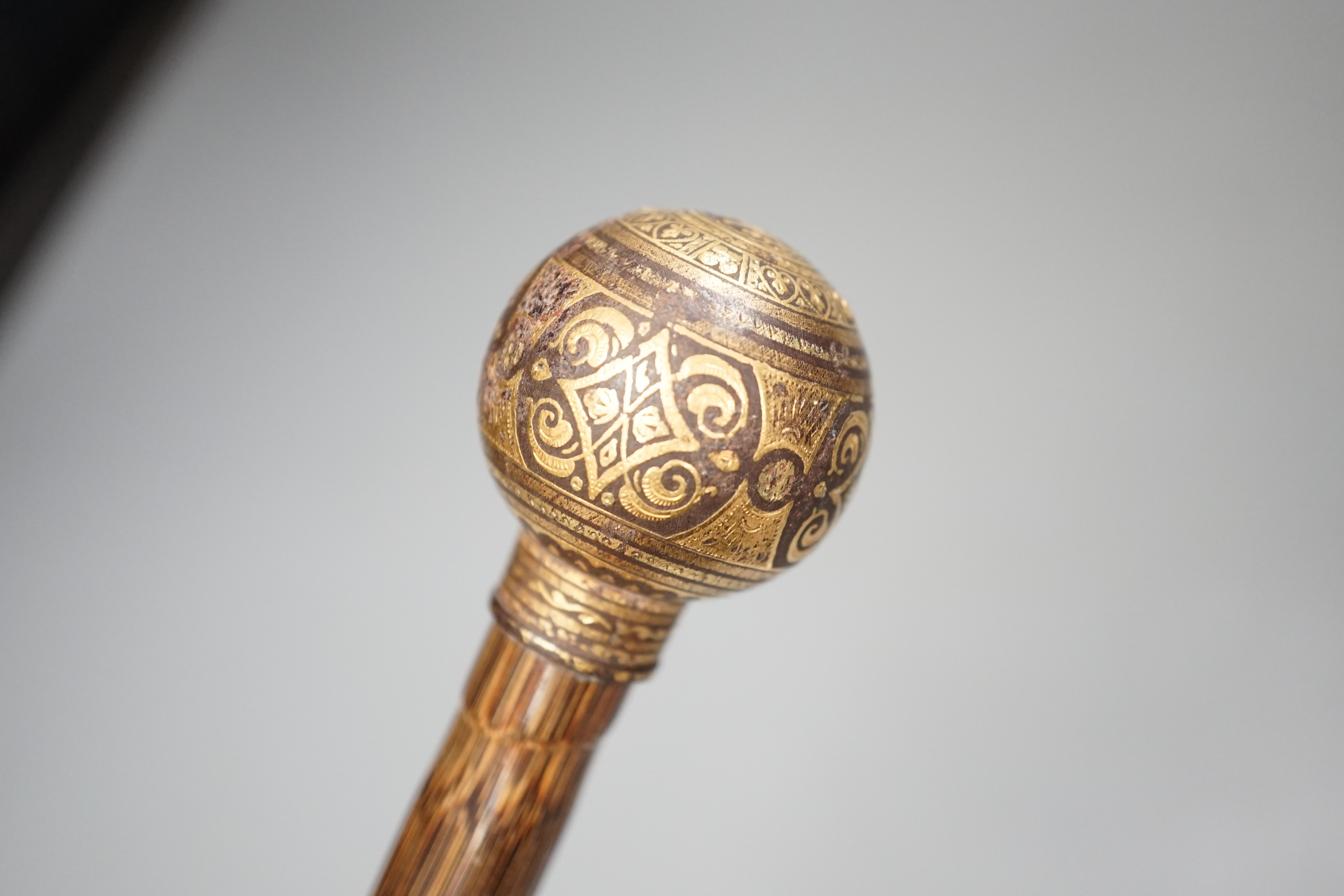 An early 20th century ivory ‘sphinx’ parasol handle, 84cm, together with another gold and iron damascened parasol handle, 62cm